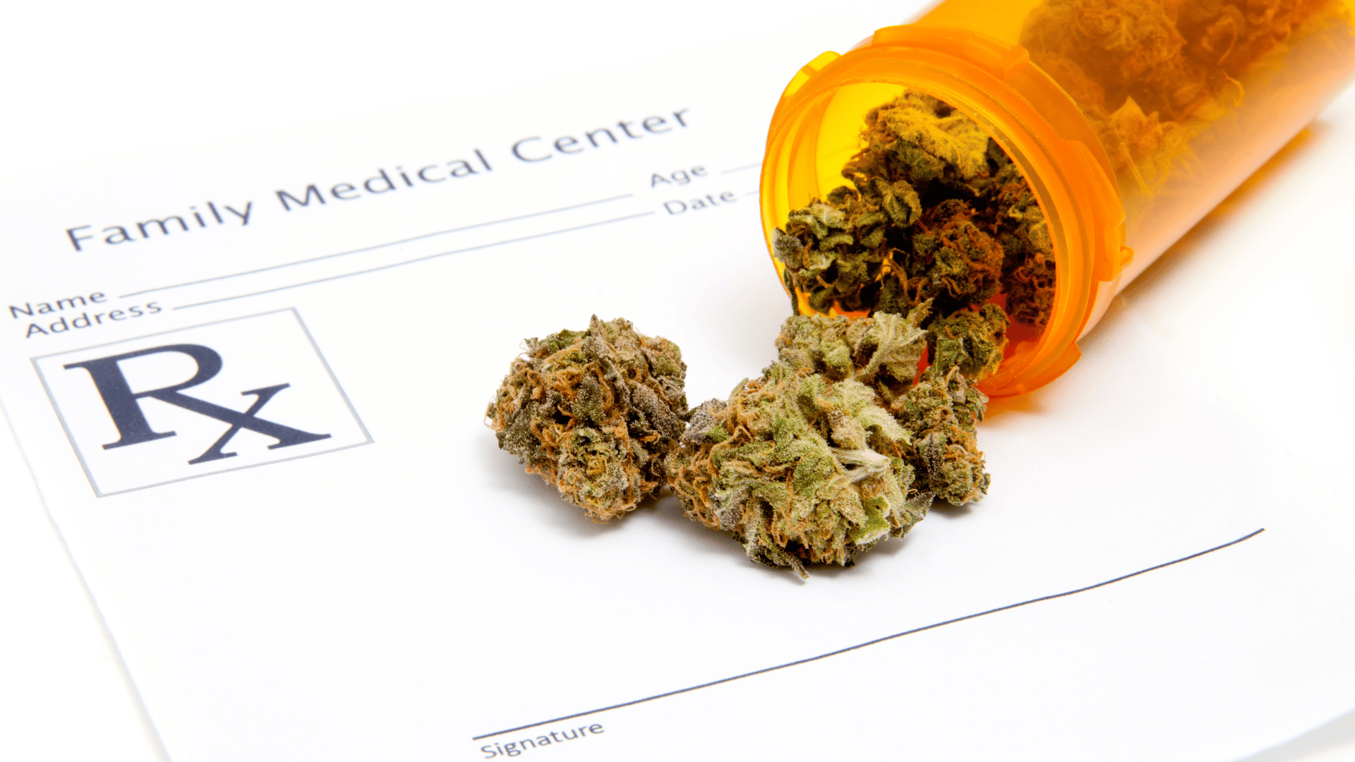 Marijuana spilling out of a small orange medication container over an RX prescription pad