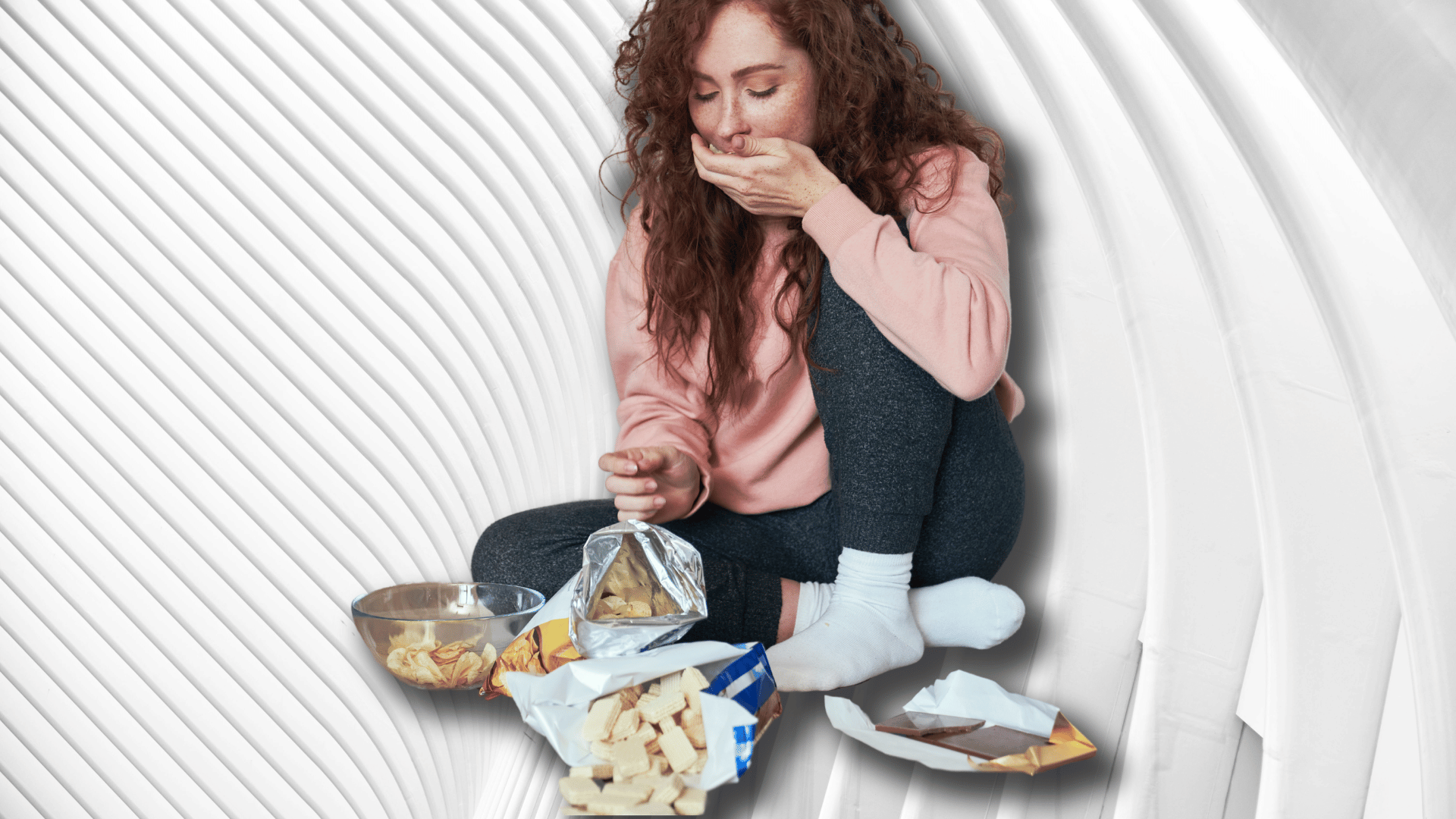 A woman sitting on a floor stuffing food into her mouth from plates of food that surround her